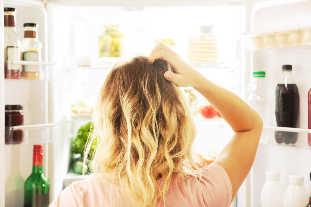 woman in front of open refridgerator