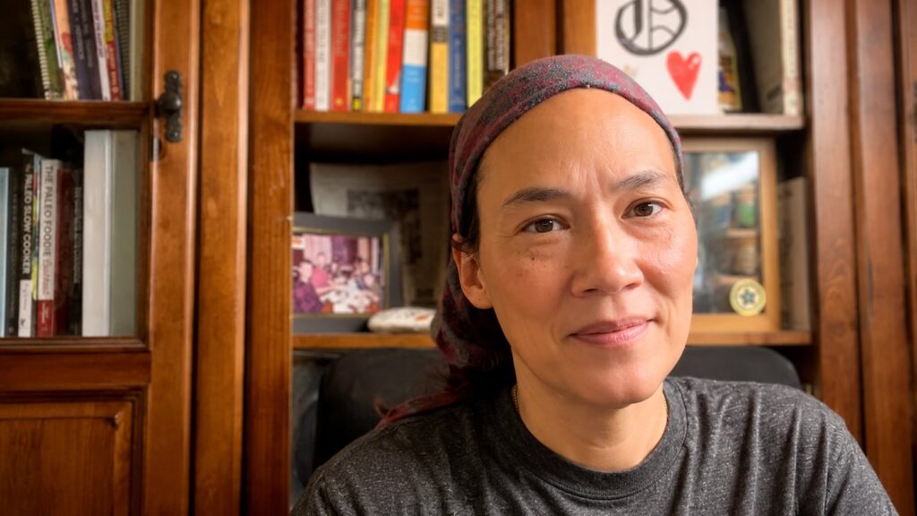 Lisa Strobridge, nutrition and functional fitness coach, seated in front of her bookshelf
